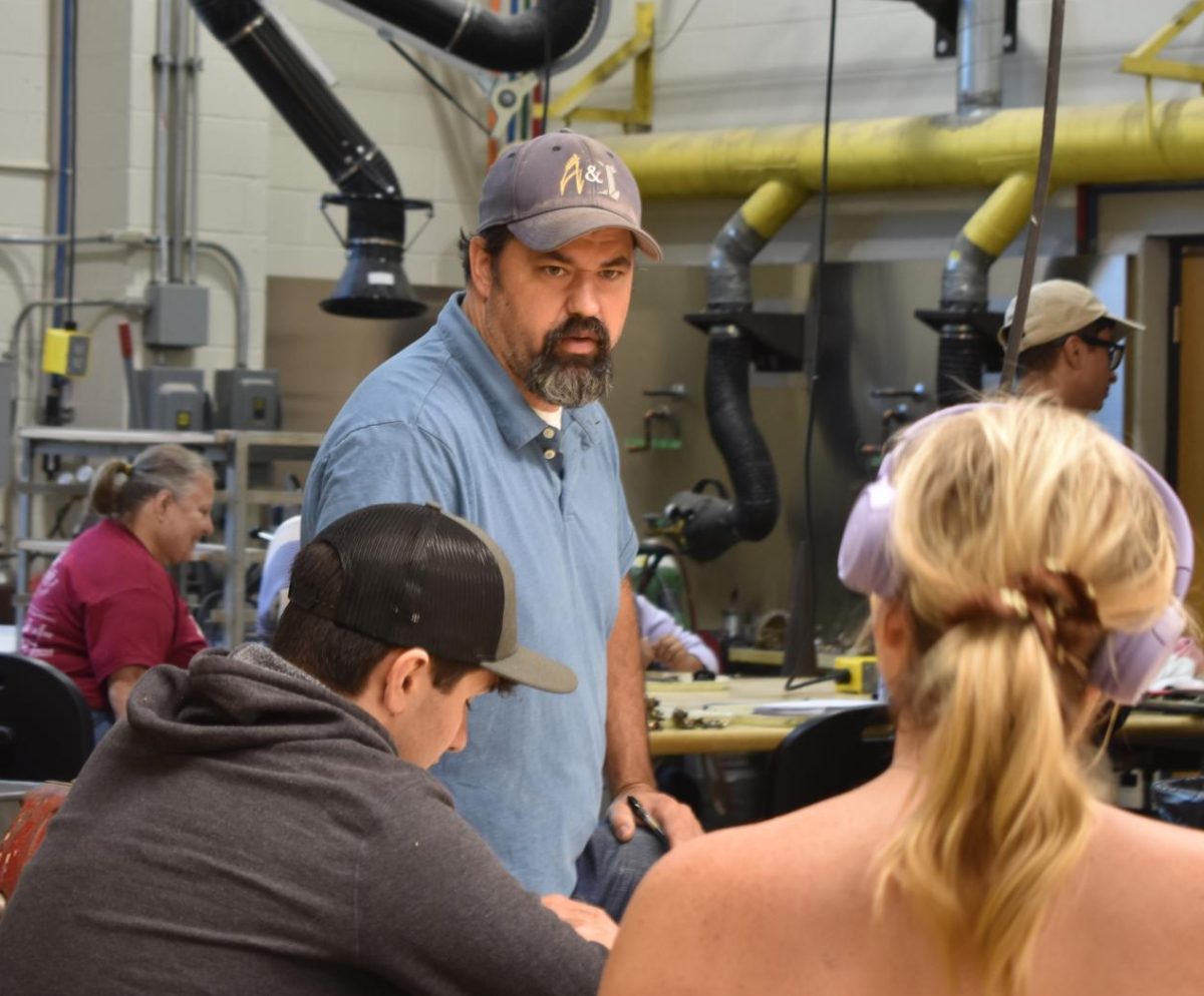 Associate Professor of Visual Arts, Daniel Josh, assists students Adoniss Hutcheson and Kate Oconnor with their sculptures, August 28.
