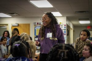 Dr. Brittany Barber enthusiastically talks with students seated in the Washington Elementary School library.