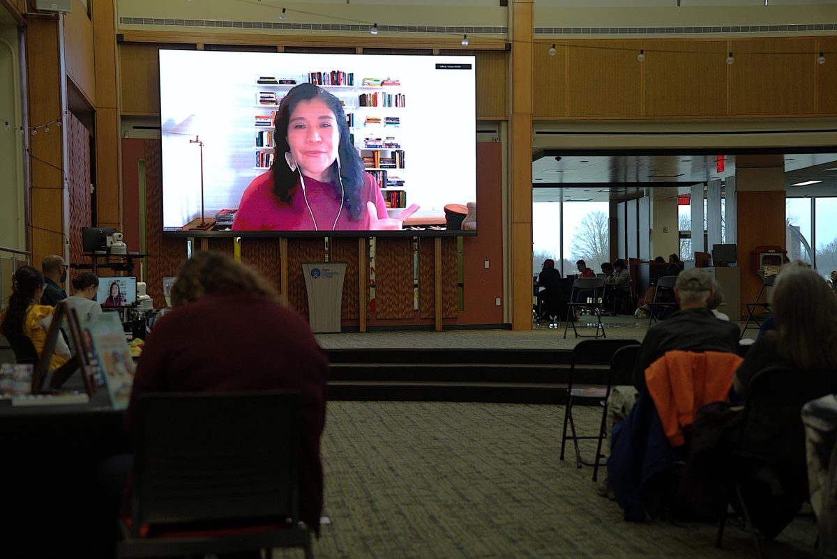 People listening to a speaker on a screen.