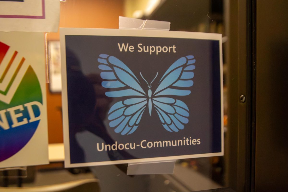 A butterfly graphic reading “We Support Undocu-Communities at ECC” is displayed on the office window of English professor Lori D. Clark in Building B at Elgin Community College on April 6, 2026. The signage is a joint effort between Undocumented Student Support Committee, We Rise student club, and the Committee on Political Education. On Jan. 8, ECC Administration promised to implement campus-wide signage regarding campus access. As of April 6, no such signage has been released. 