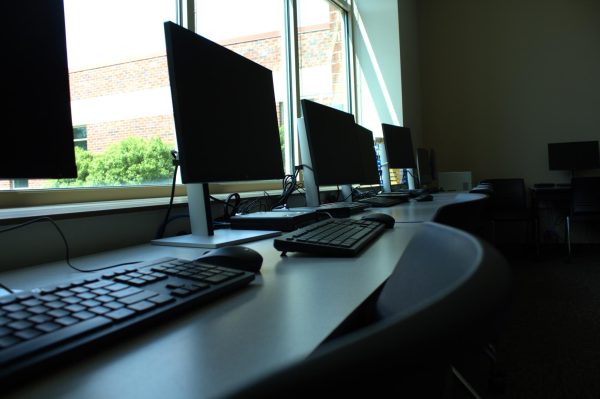 Desktop computers in a dark classroom.