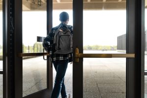 A student exits the second-level Building B doors, which doesn't have an ADA (Americans with Disabilities Act) button for disabled students, on May 6, 2026. Some doors throughout campus don't have ADA buttons installed, making it more difficult for students with physical disabilities to get to and from locations efficiently.